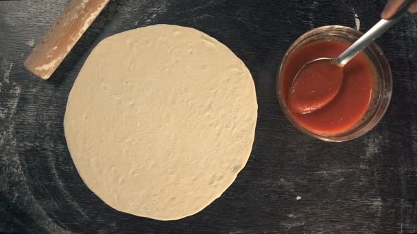 Chef extendiendo salsa de tomate. Haciendo pizza — Vídeos de Stock