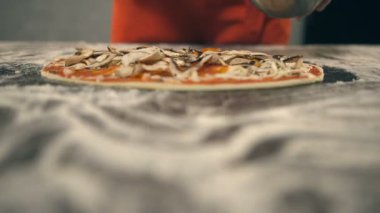 Şef petrol pizza üzerine koyar. Ağır çekim