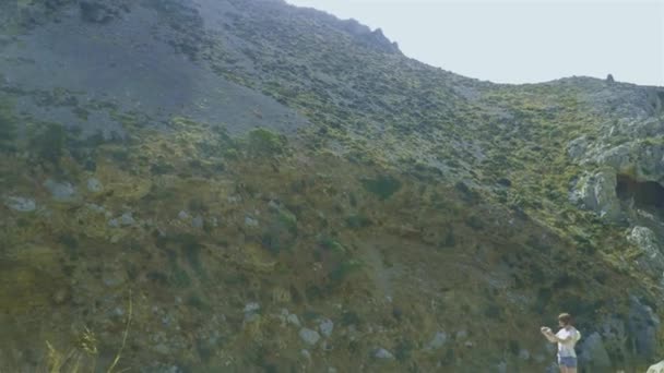 Mujer toma una foto en una cámara inteligente en el fondo de las rocas del cañón y la naturaleza salvaje — Vídeos de Stock