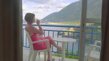 otel ve lagün deniz seyir balkon oturan Kızıl saçlı kız