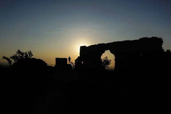 Frau Einer Beleuchteten Ruine Mit Der Sonne Über Dem Horizont — Stockfoto