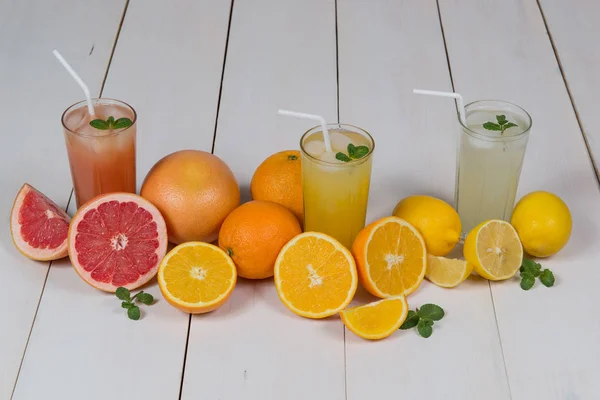 Los jugos de la fruta sobre la mesa blanca — Foto de Stock