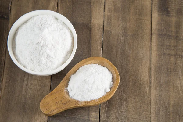 Baking soda into the bowl and wooden spoon — Stock Photo, Image