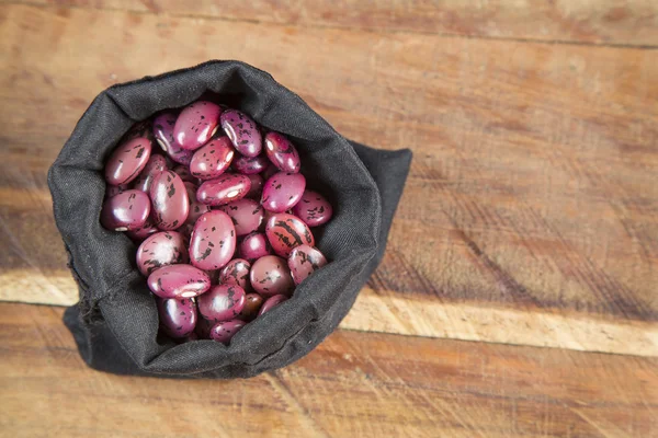 Fagioli pinto sparsi su sacchetto di tela grezza — Foto Stock