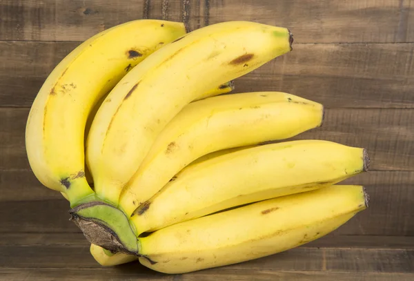 Bunch of fresh bananas on the wooden background