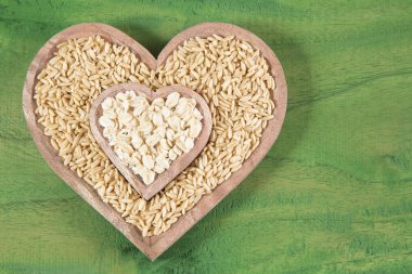 Ahşap kase tohum ve yulaf gevreği kalp şeklinde