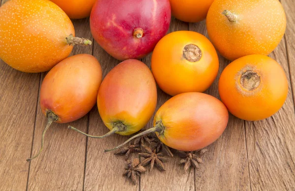 Heerlijke tropische vruchten op de houten achtergrond — Stockfoto