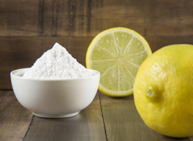 Baking soda and lemon on wooden table clipart