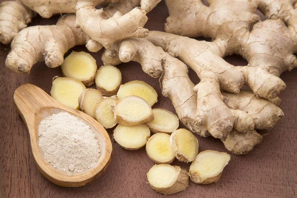 Taze dilimlenmiş zencefil kökü ve zemin ahşap arka plan - Zingiber officinale zencefil