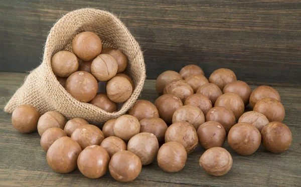 Noz de macadâmia orgânica na mesa de madeira (Macadamia integrfolia ) — Fotografia de Stock