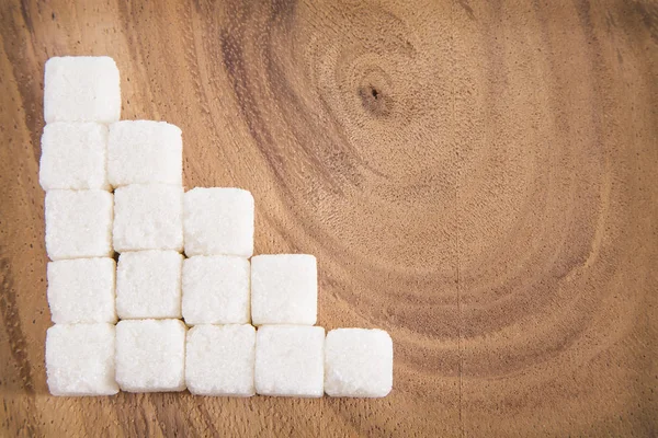 Cubetti di zucchero bianco sulla superficie di legno — Foto Stock