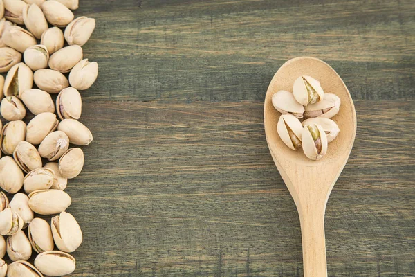 Nueces de pistacho Salado colocado en una cuchara de madera — Foto de Stock