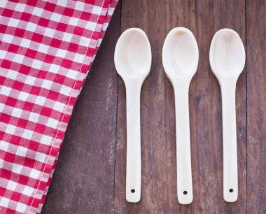 Damalı peçete ve ahşap zemin üzerine kaşık