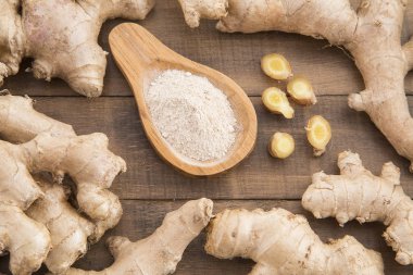 Taze dilimlenmiş zencefil kökü ve zemin ahşap arka plan - Zingiber officinale zencefil