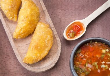 Ahşap arka planda baharatlı soslu Kolombiya böreği.