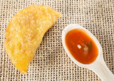 Ahşap arka planda baharatlı soslu Kolombiya böreği.