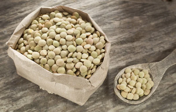 Raw lentils in the paper bag - Lens culinaris — Stock Photo, Image