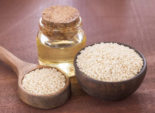 Cam Kavanoz ve susam tohumu tahta kaşık - Sesamum indicum üzerinde susam yağı