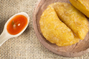 Ahşap arka planda baharatlı soslu Kolombiya böreği.