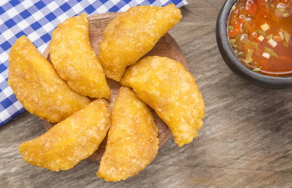 Empanada colombiana con salsa picante sobre fondo de madera —  Fotos de Stock