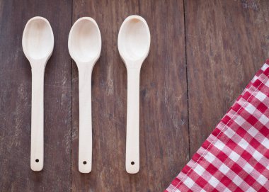 Damalı peçete ve ahşap zemin üzerine kaşık