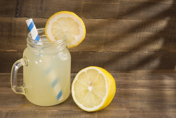 Agua y jugo de limón sobre fondo de madera —  Fotos de Stock