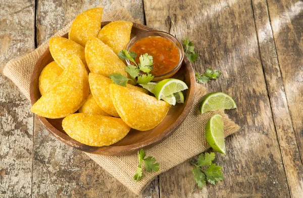 Empanada colombiana con salsa picante sobre fondo de madera — Foto de Stock