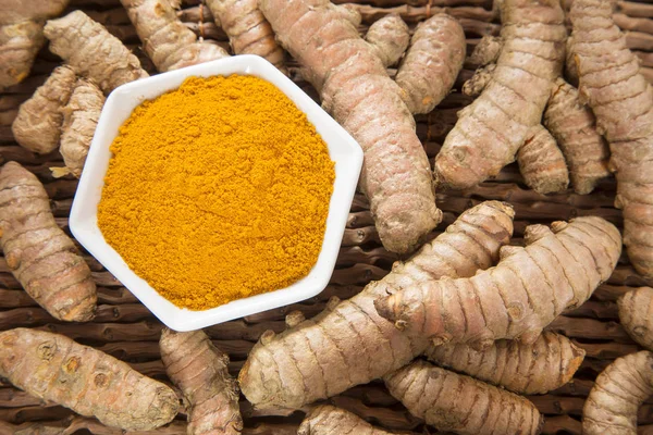 Zerdeçal tozu ve ahşap zemin üzerine taze zerdeçal