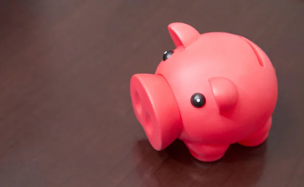 Red piggy bank on wooden background