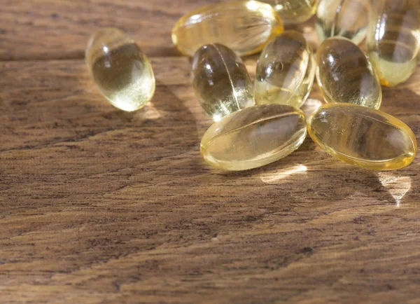 Vitamin D in capsules on wooden background