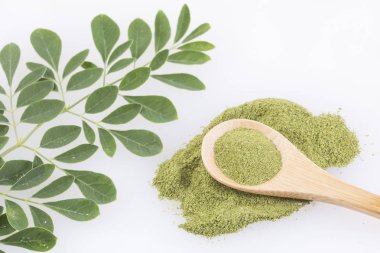 Moringa yaprakları ve beyaz arka plan üzerinde tozu