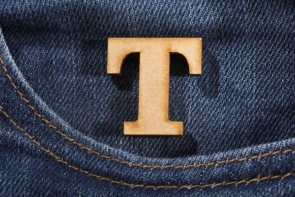 Buchstabe t des Alphabets - Blue Jeans Textur Hintergrund. Ansicht von oben — Stockfoto