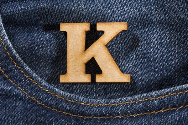 Lettera K dell'alfabeto - sfondo di struttura di jeans azzurri. Vista dall'alto — Foto Stock
