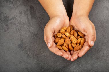 Prunus dulcis - soyulmuş bademleri tutan eller