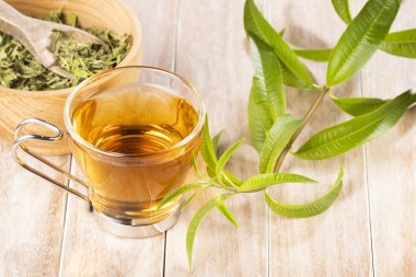 Tahta kasede limon verbena yaprağı ve ahşap masada verbena çayı. Aloysia citrodora