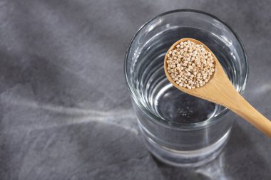 Organik kinoa tohumlu kaşık ve bir bardak filtrelenmiş su - Chenopodium kinoa