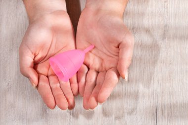 Aybaşı bardağı tutan kadın - kadın hijyeni, jinekoloji ve sağlık konsepti