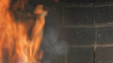 Eller şöminenin ateşini ısıtır.