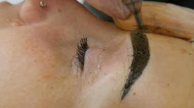 Kadınlar kaşlarına kalıcı makyaj yapar.