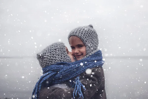 Flicka i stickad grå hatt kramar sin frusna lillebror — Stockfoto