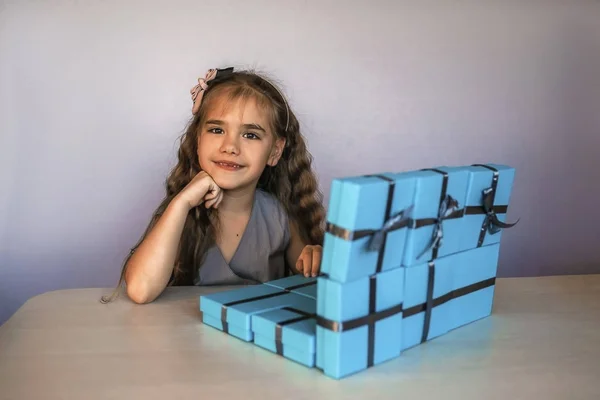 파란 선물 상자 근처에 있는 귀여운 소녀는 랩탑처럼 만들어 졌다 — 스톡 사진