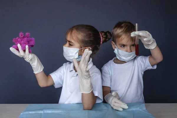 Criança bonito usando máscara respiradora e luvas de medicina segurando um b — Fotografia de Stock