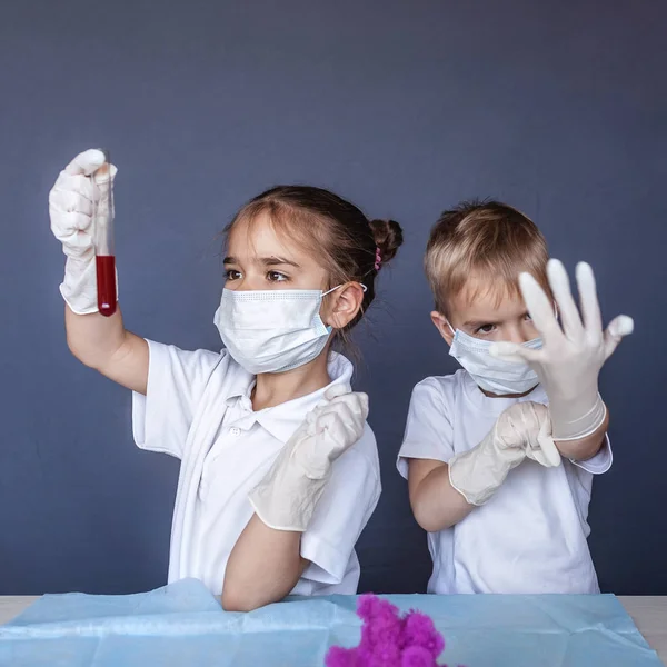 Criança bonito usando máscara respiradora e luvas de medicina segurando um b — Fotografia de Stock