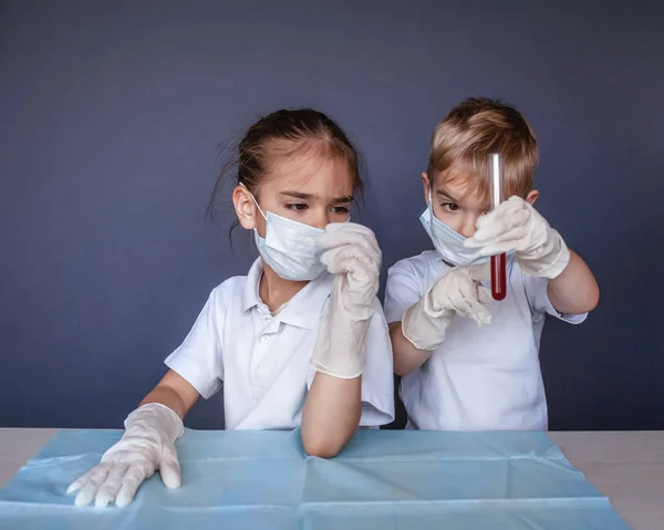 Criança bonito usando máscara respiradora e luvas de medicina segurando um b — Fotografia de Stock