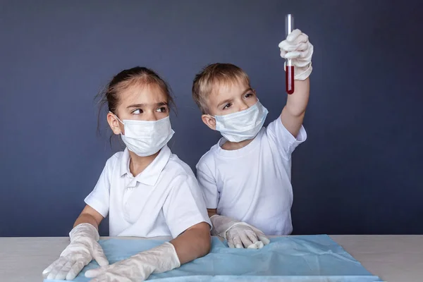 Criança bonito usando máscara respiradora e luvas de medicina segurando um b — Fotografia de Stock
