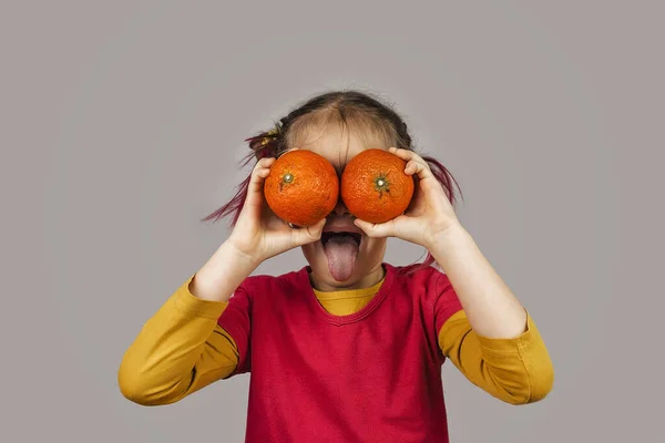 Причудливый ребенок держит деформировать неправильного цвета фрукты и овощи , Лицензионные Стоковые Изображения