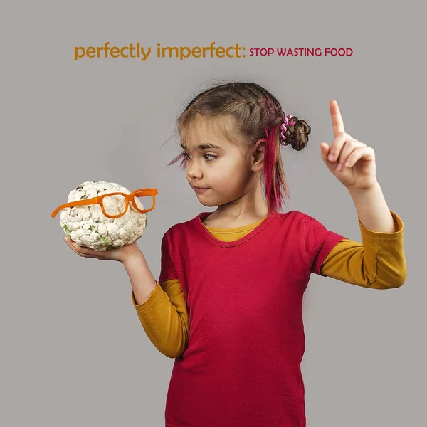 Причудливый ребенок держит деформировать неправильного цвета фрукты и овощи , Стоковое Фото