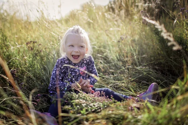 Gyerekek szórakozás a zöld fű a virágok a réten, g — Stock Fotó