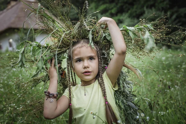 Jolie fille portant une couronne de fleurs d'été et de blé doré à t — Photo