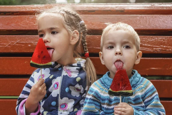 미국에서 수박 맛 이 나는 밝은 빨간 사탕을 먹는 두 아이 — 스톡 사진